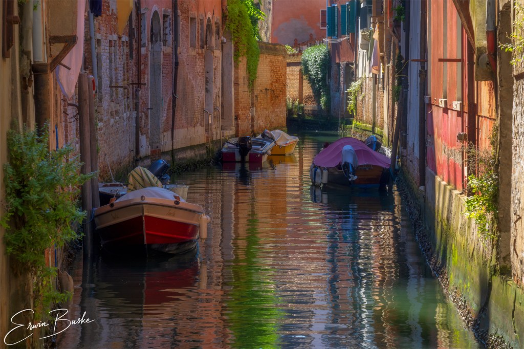 Colorful Venice architecture broken into abstract reflections on canal water.